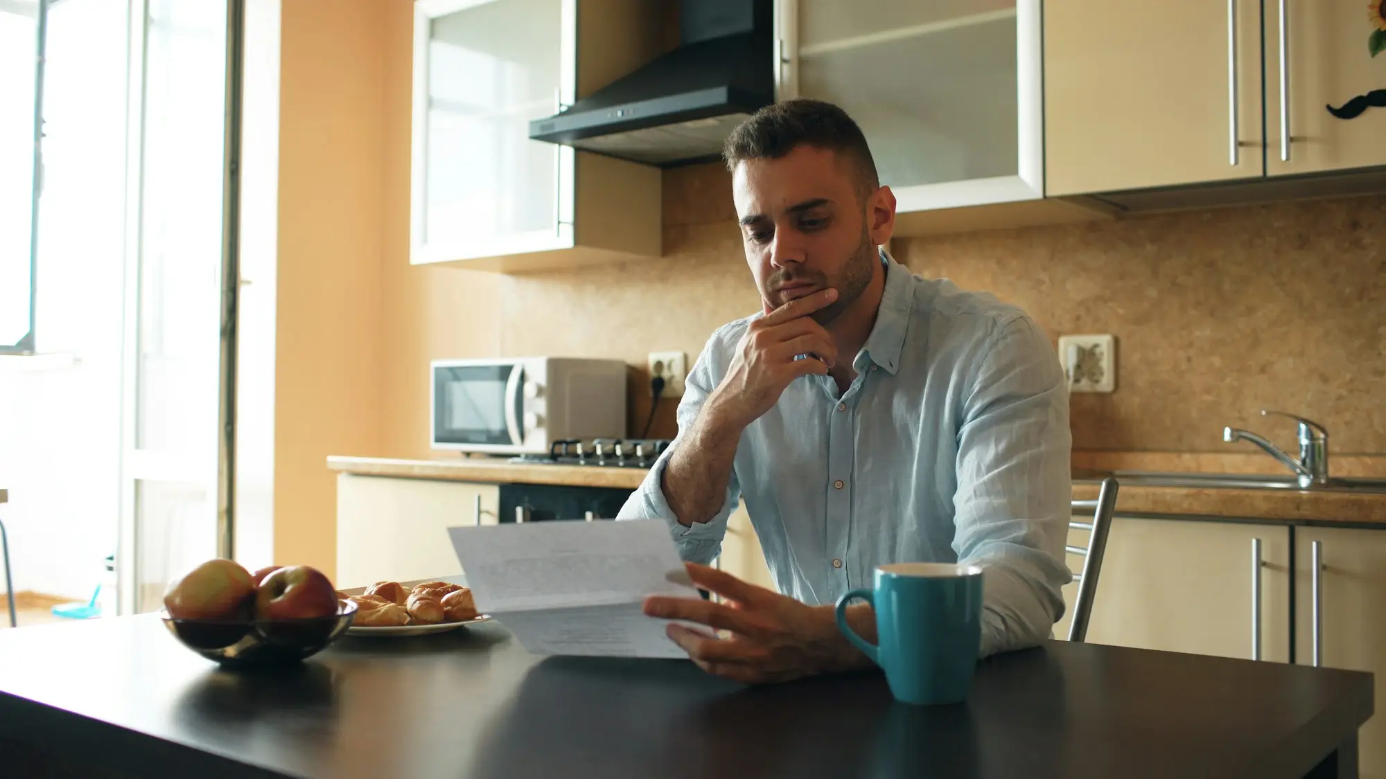 Business owner reading a tax letter at the kitchen table