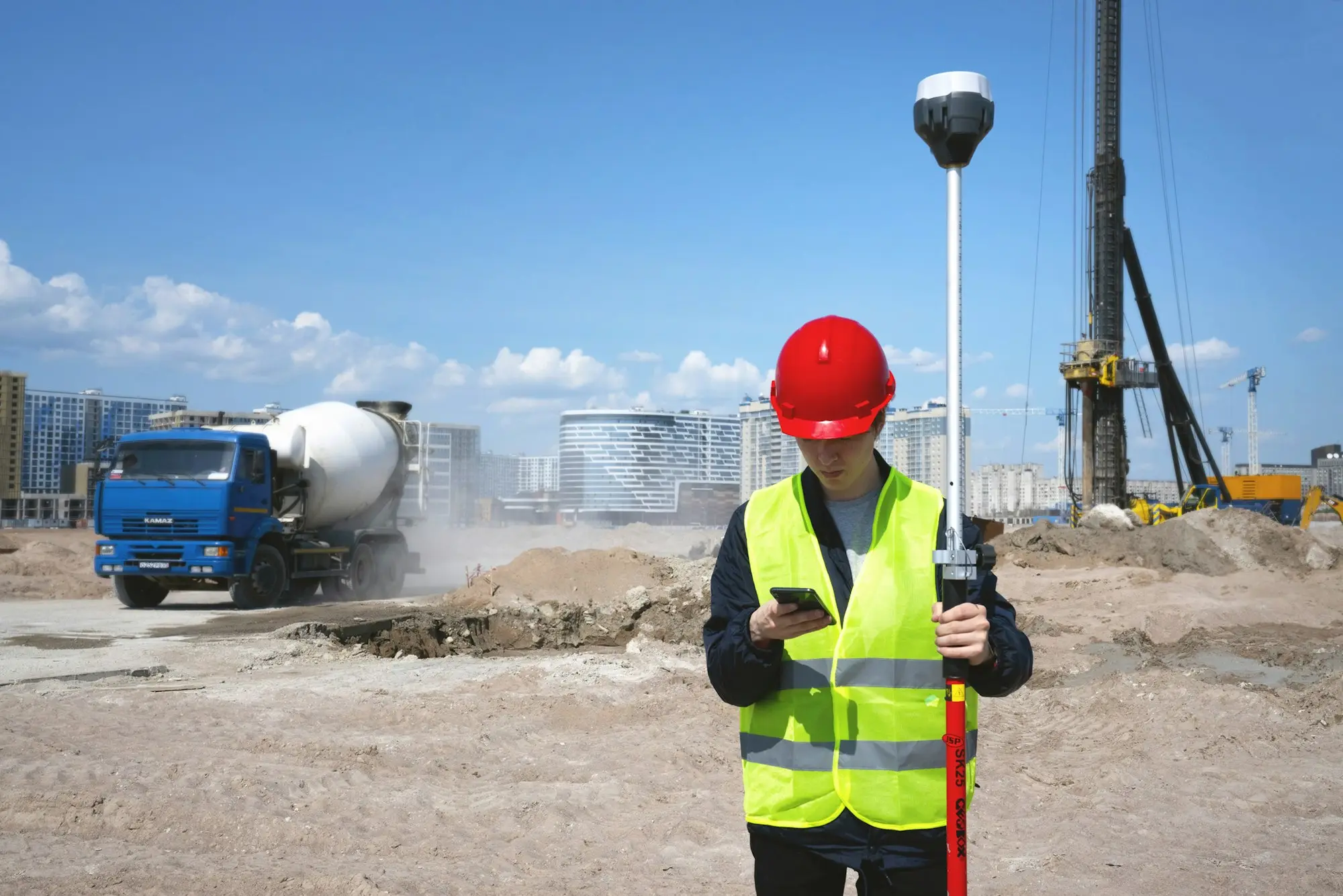 Builder in hi-vis and hard hat on a construction site with a concrete truck