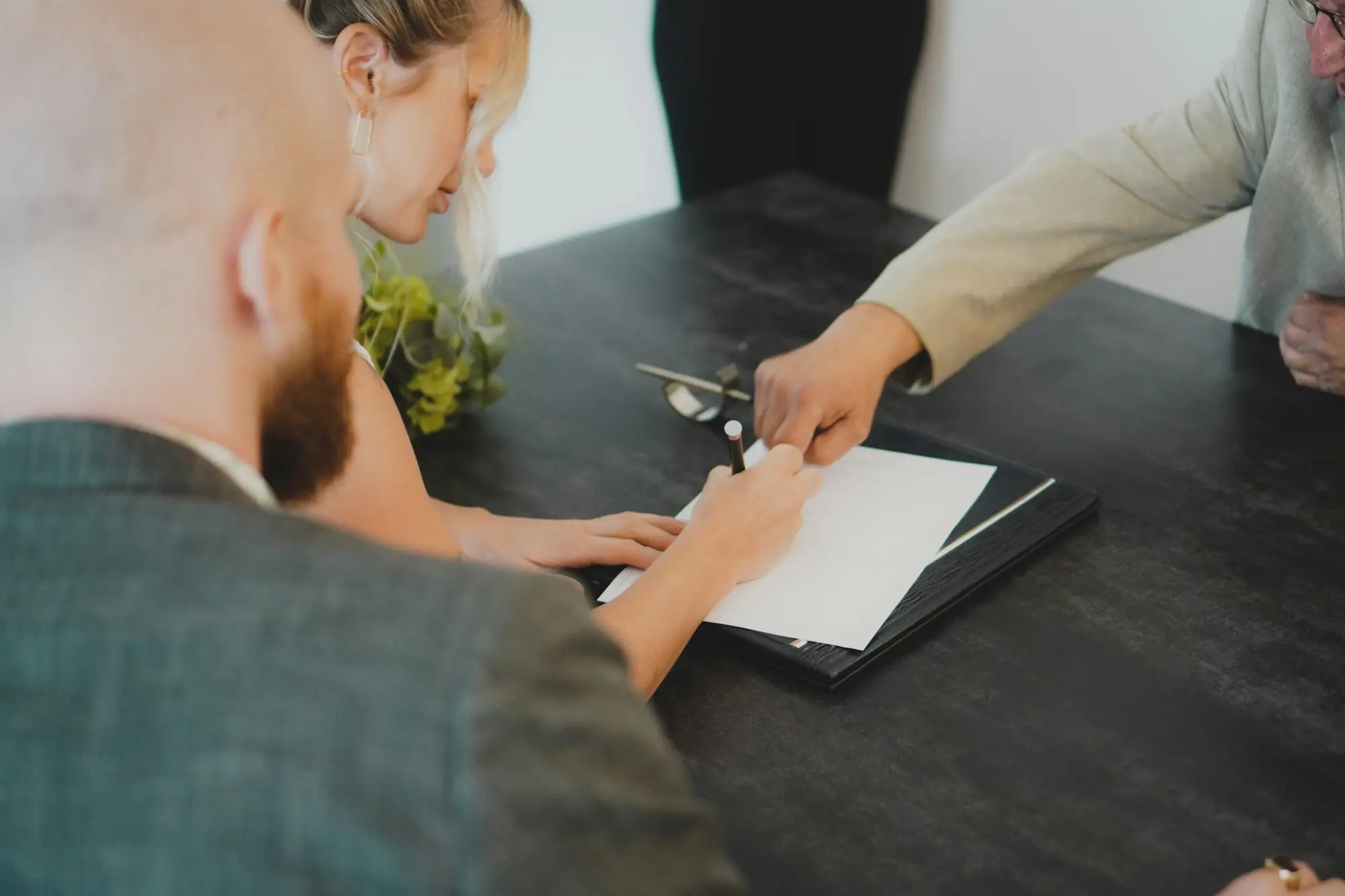 Family business owners signing documents with an adviser