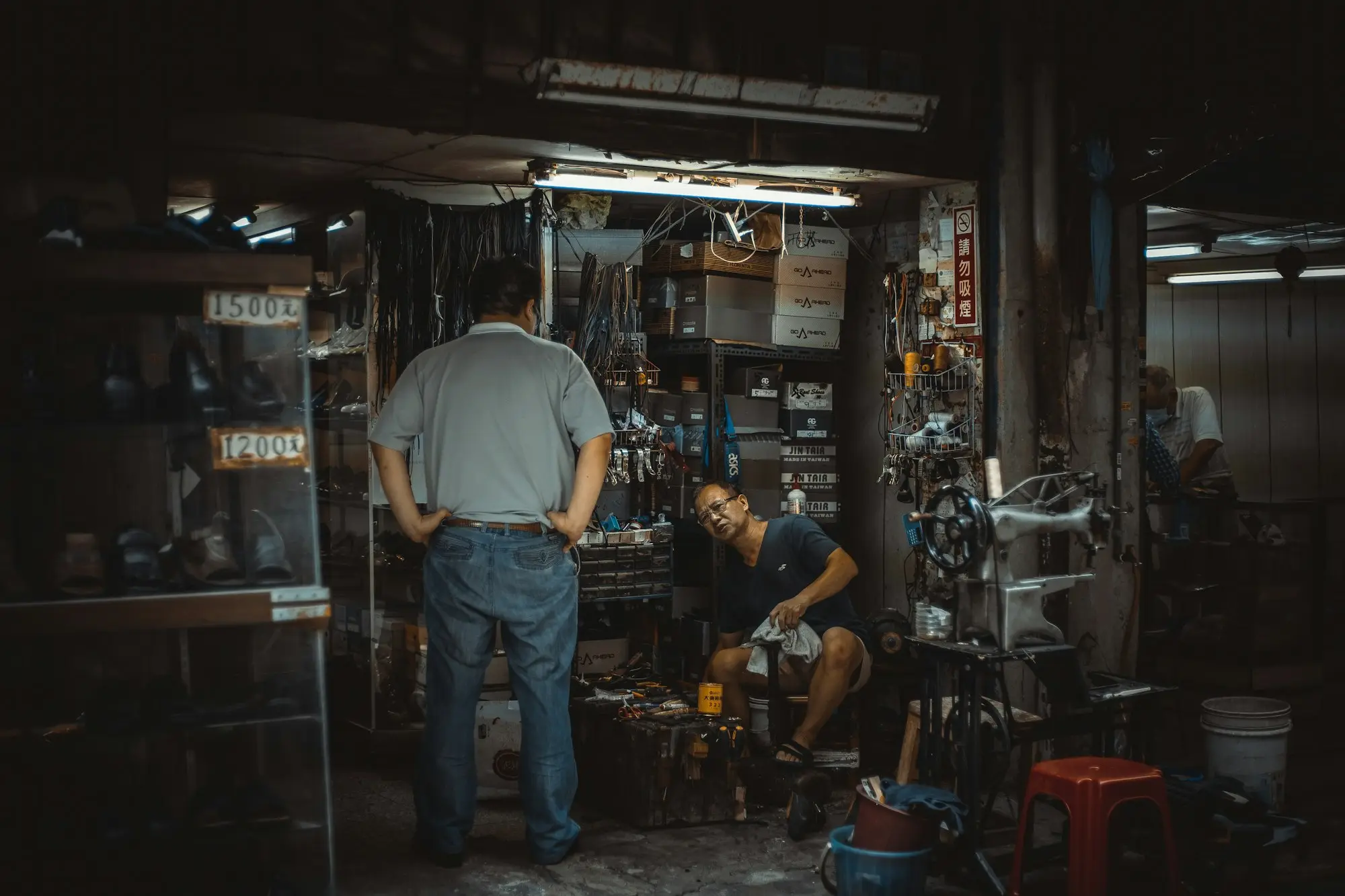 Mechanic talking with a customer inside a busy workshop