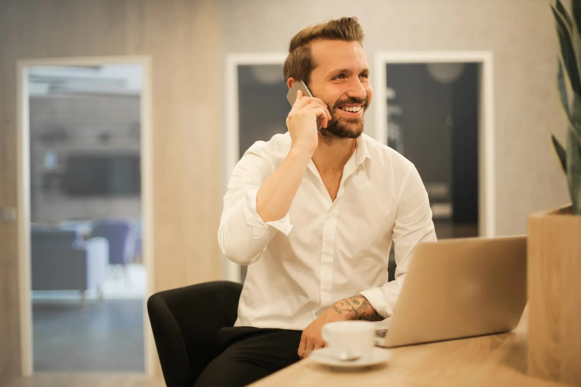 Business owner smiling during a phone call at his desk