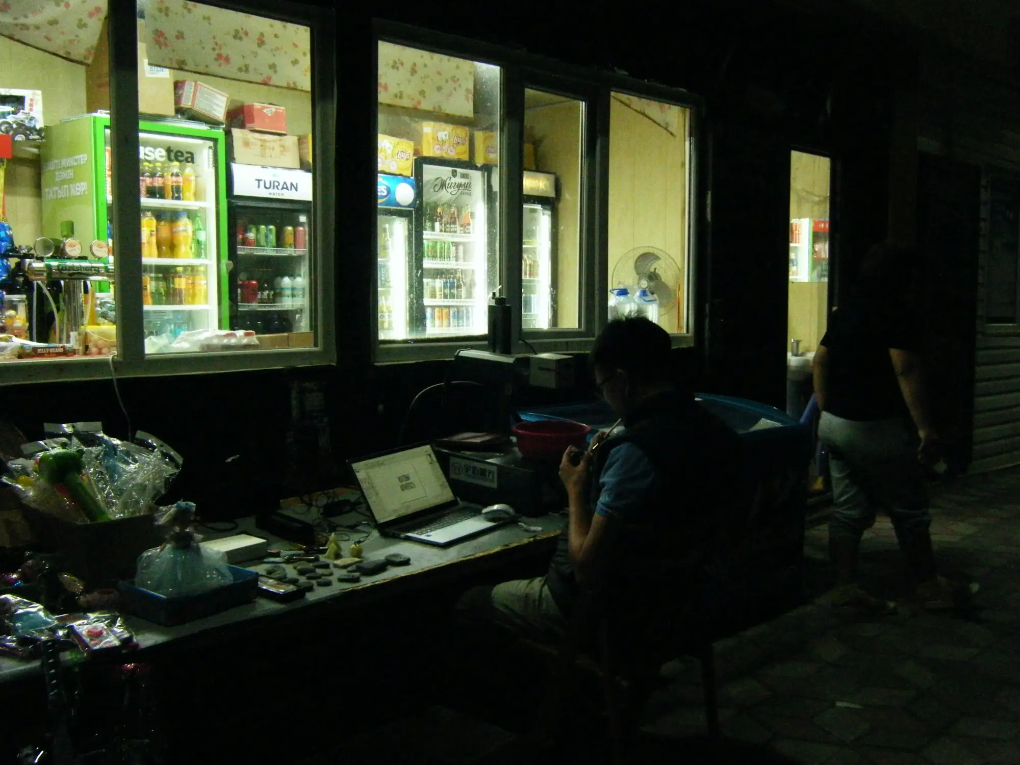 Shop owner working on a laptop in a quiet store after hours